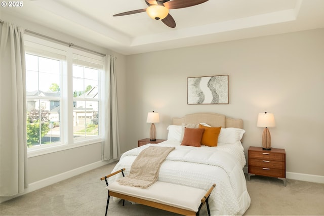 16922 NW Madrone St, Portland, OR 97229 - bedroom featuring light carpet, a tray ceiling, and baseboards