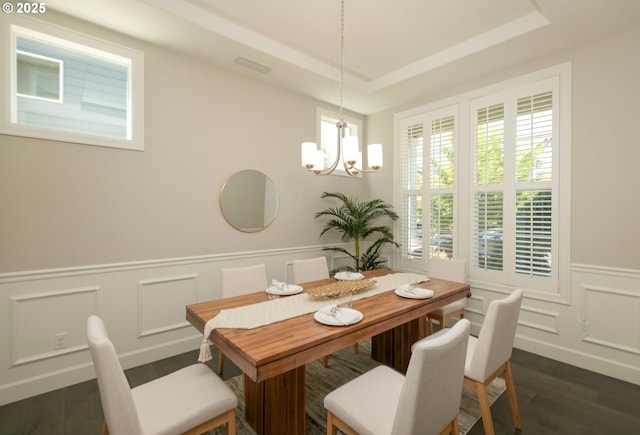 16922 NW Madrone St, Portland, OR 97229 - dining space featuring dark wood-style floors, a decorative wall, a chandelier, a wainscoted wall, and a tray ceiling