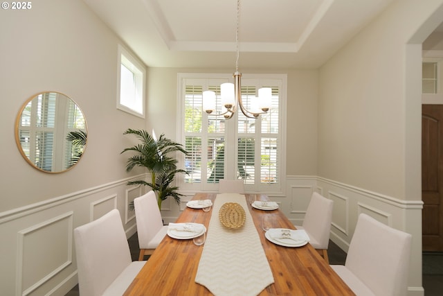 16922 NW Madrone St, Portland, OR 97229 - dining area featuring a chandelier, a decorative wall, wood finished floors, wainscoting, and arched walkways