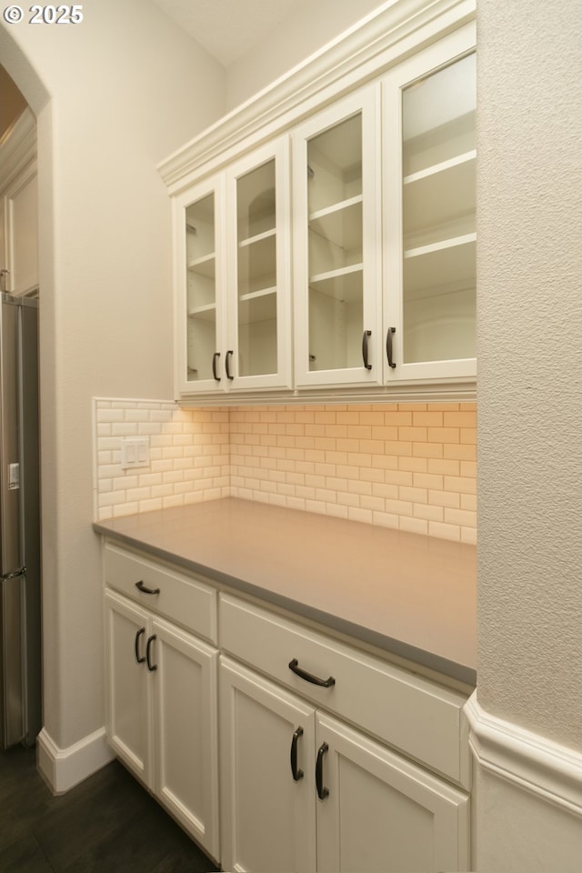 16922 NW Madrone St, Portland, OR 97229 - bar area with freestanding refrigerator, backsplash, arched walkways, and dark wood finished floors