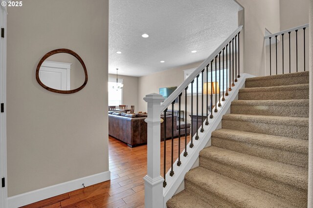14670 SW 78th Ave, Tigard, OR 97224 - stairway with a textured ceiling, hardwood / wood-style floors, recessed lighting, a chandelier, and baseboards