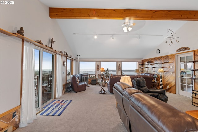 carpeted living room with high vaulted ceiling, track lighting, and beam ceiling