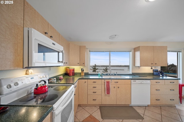 kitchen featuring sink, light tile patterned floors, light brown cabinetry, and white appliances