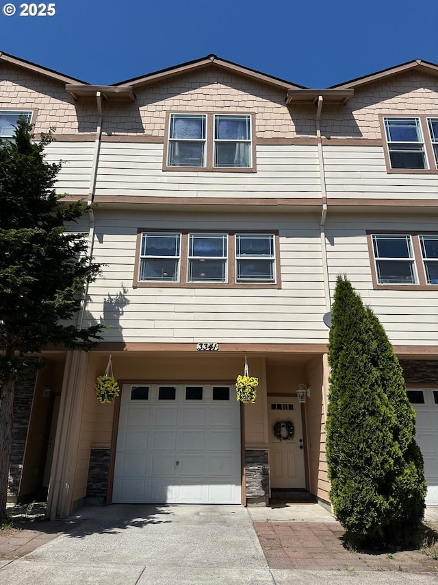 view of property featuring an attached garage and driveway