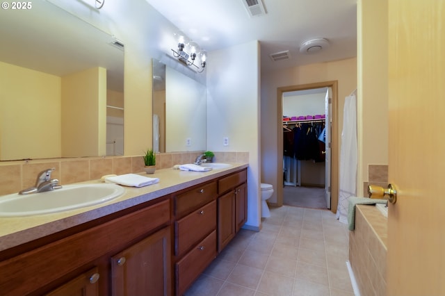 full bath featuring tile patterned floors, double vanity, toilet, and a spacious closet