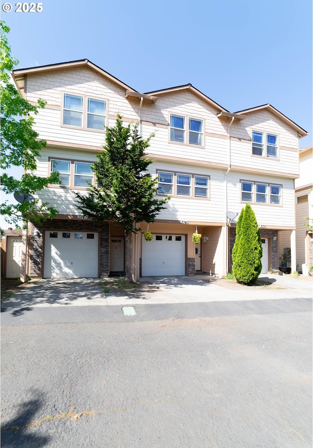multi unit property featuring a garage and driveway
