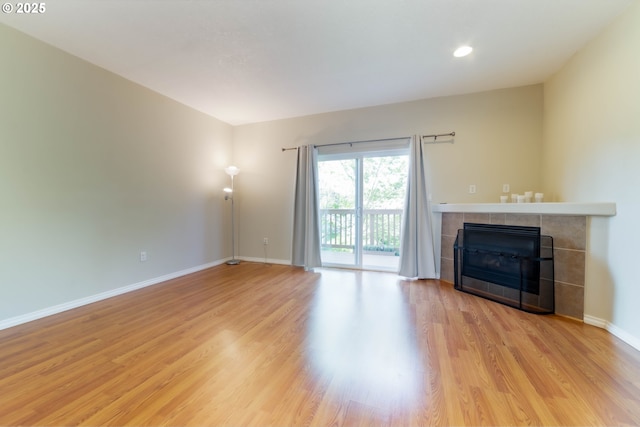 unfurnished living room with a fireplace, light wood-type flooring, baseboards, and recessed lighting