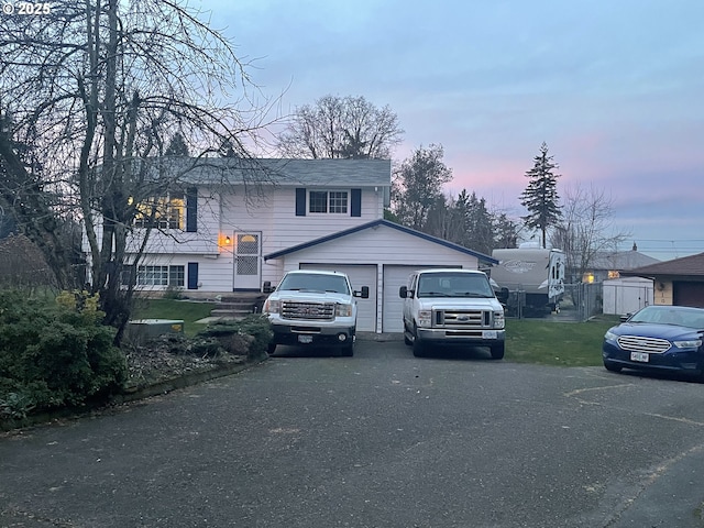 split foyer home featuring a garage and a lawn