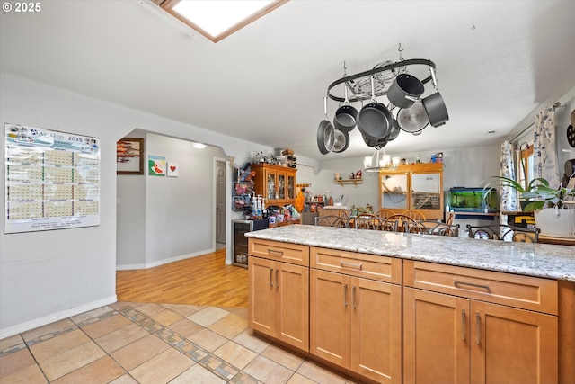 kitchen with an inviting chandelier, light stone countertops, and light tile patterned floors