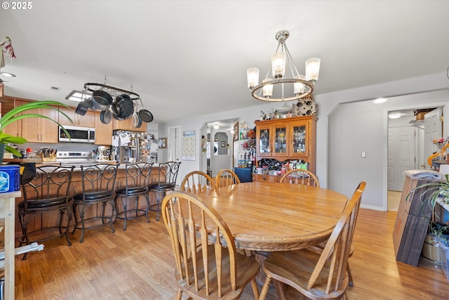 dining area featuring a notable chandelier and light hardwood / wood-style floors