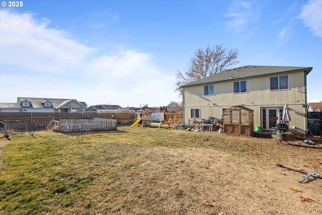 back of property with a playground and a lawn