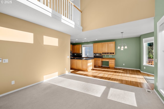 kitchen featuring a notable chandelier, pendant lighting, a towering ceiling, and sink