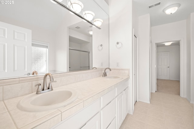 bathroom featuring vanity, tile patterned floors, and a shower with shower door