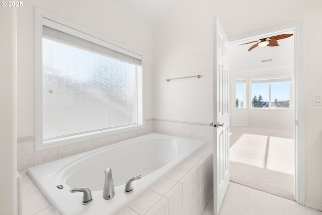 bathroom with tiled bath, ceiling fan, and tile patterned floors