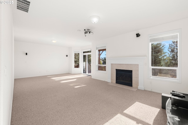 unfurnished living room featuring a tile fireplace and carpet