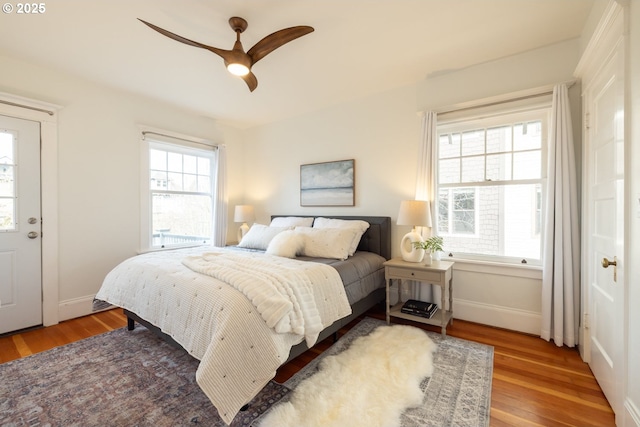 bedroom with a ceiling fan, baseboards, and wood finished floors