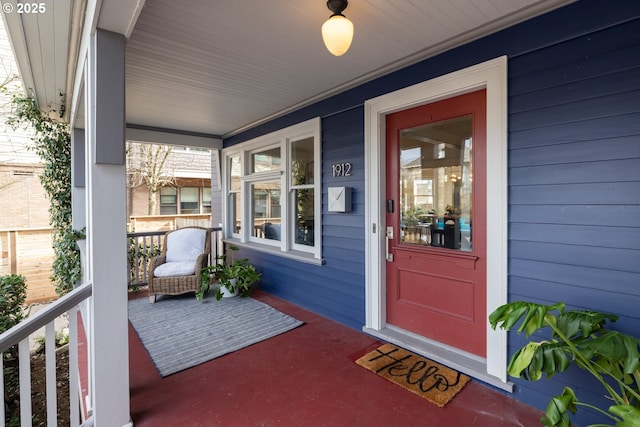 property entrance featuring covered porch and brick siding