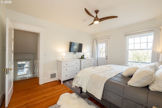 bedroom with visible vents, ceiling fan, baseboards, and wood finished floors