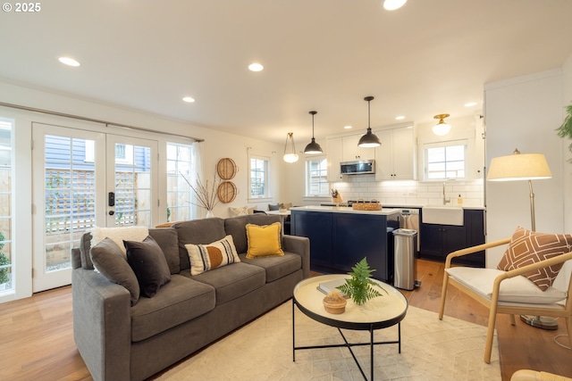 living room featuring light wood finished floors, french doors, and recessed lighting