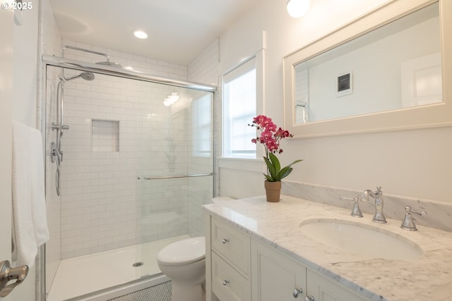 bathroom with vanity, a shower stall, toilet, and recessed lighting