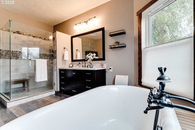 bathroom featuring vanity, hardwood / wood-style flooring, and plus walk in shower