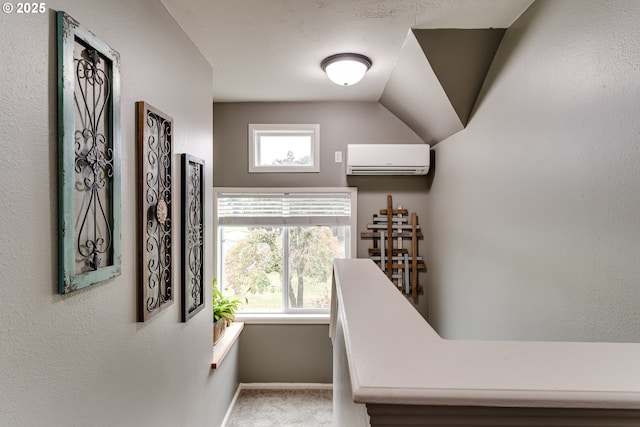 stairs featuring a wall unit AC, a healthy amount of sunlight, and carpet flooring