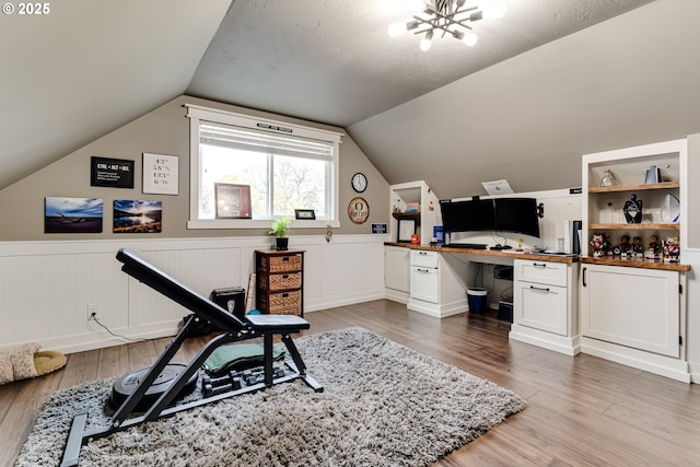 office featuring an inviting chandelier, wood-type flooring, and vaulted ceiling