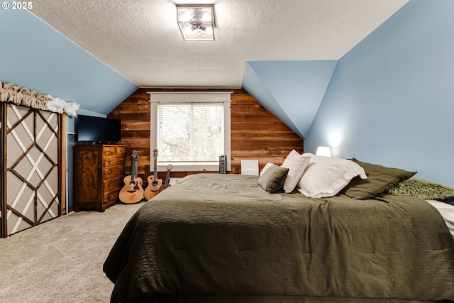 bedroom with wooden walls, vaulted ceiling, a textured ceiling, and carpet flooring