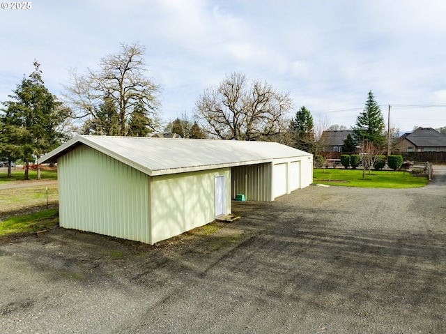 view of outdoor structure featuring a garage and a lawn