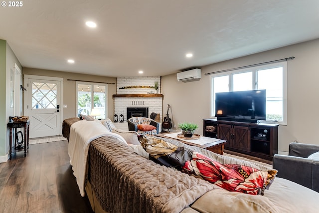 living room featuring dark hardwood / wood-style flooring, a wall mounted air conditioner, and a fireplace