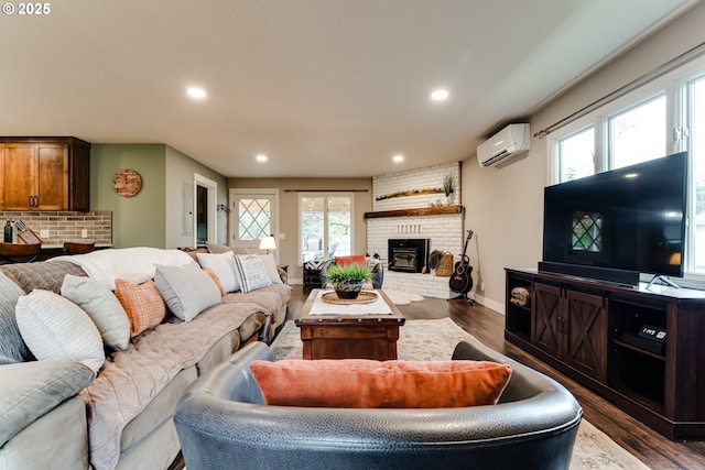 living room with a brick fireplace, dark wood-type flooring, and a wall unit AC