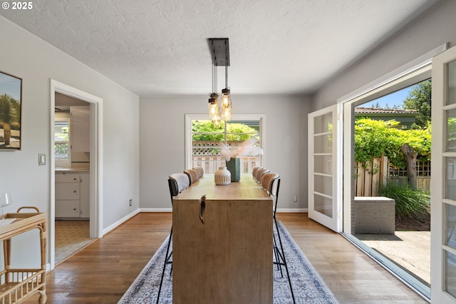 17787 Kelok Rd, Lake Oswego, OR 97034 - dining room featuring wood finished floors, a textured ceiling, and baseboards