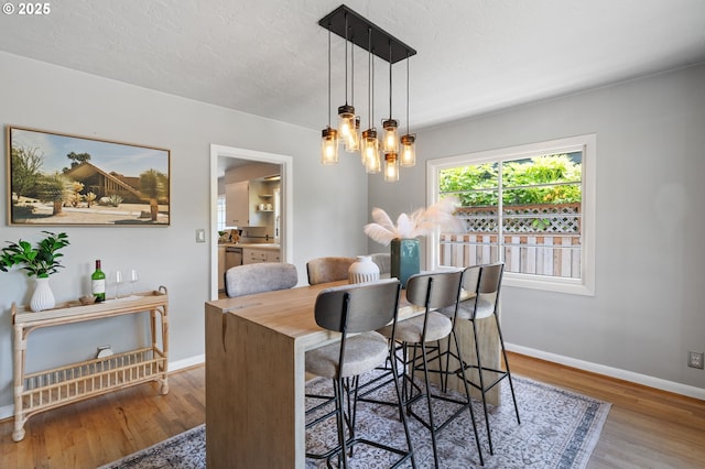17787 Kelok Rd, Lake Oswego, OR 97034 - dining room featuring wood finished floors, baseboards, a chandelier, and a textured ceiling