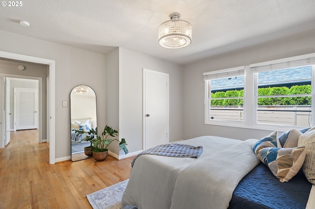 17787 Kelok Rd, Lake Oswego, OR 97034 - bedroom with a chandelier, light wood-style floors, and baseboards