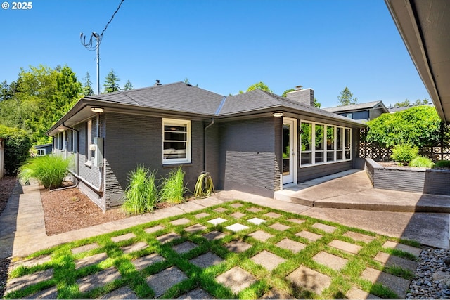 17787 Kelok Rd, Lake Oswego, OR 97034 - rear view of property featuring a patio, brick siding, a chimney, and roof with shingles