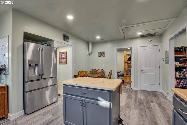 kitchen featuring stainless steel fridge, light hardwood / wood-style floors, wooden counters, and a kitchen island