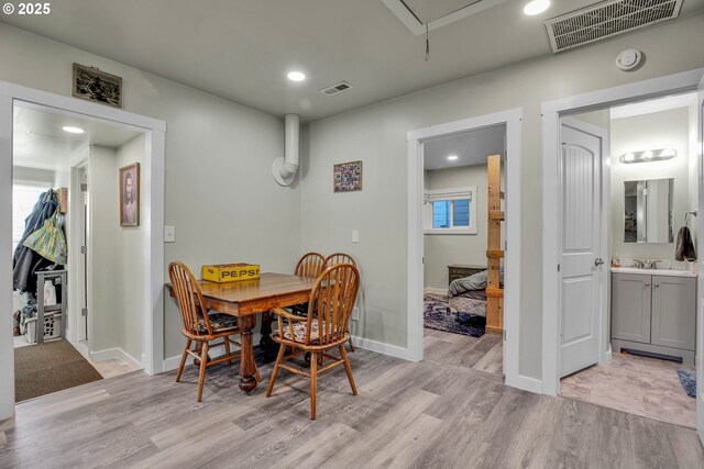 dining area featuring sink and light wood-type flooring