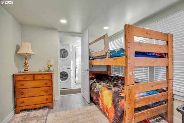 bedroom with stacked washer and dryer and light wood-type flooring