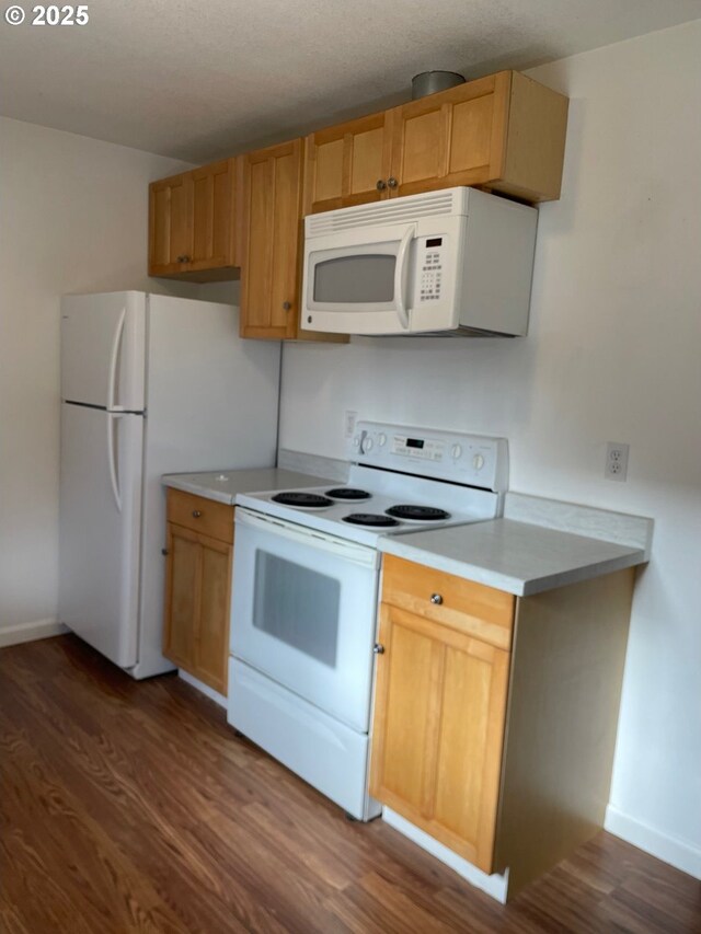 kitchen with white appliances, dark hardwood / wood-style floors, and a textured ceiling