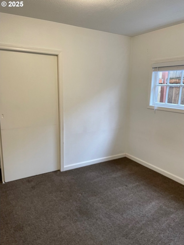 empty room featuring dark carpet