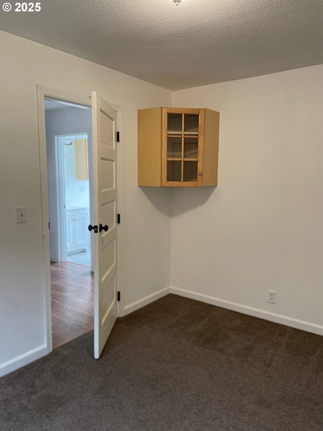 carpeted empty room with a textured ceiling