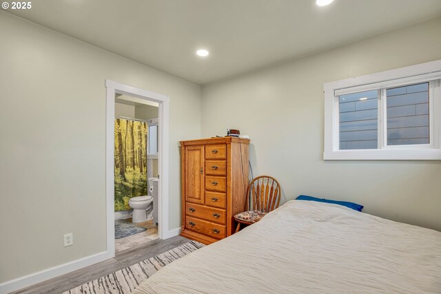 bedroom with wood-type flooring and connected bathroom