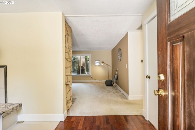entryway with baseboards, a textured ceiling, and wood finished floors