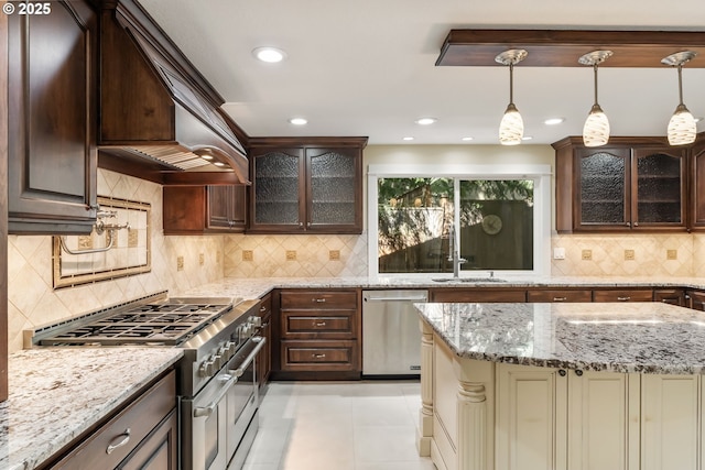 kitchen featuring decorative backsplash, dark brown cabinets, glass insert cabinets, a sink, and stainless steel appliances