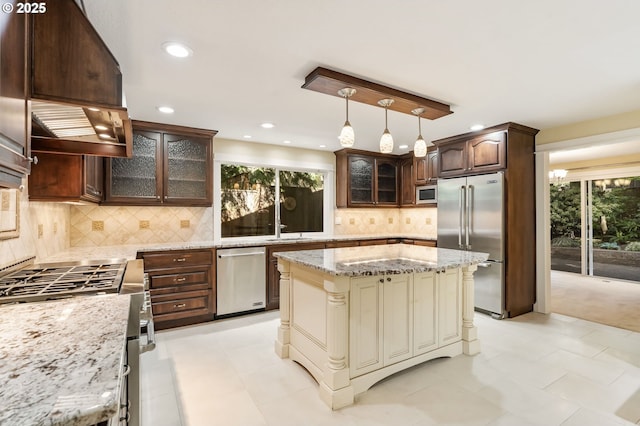 kitchen with light stone countertops, high end appliances, dark brown cabinets, and glass insert cabinets