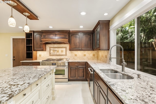 kitchen with a sink, light stone counters, stainless steel appliances, and custom range hood