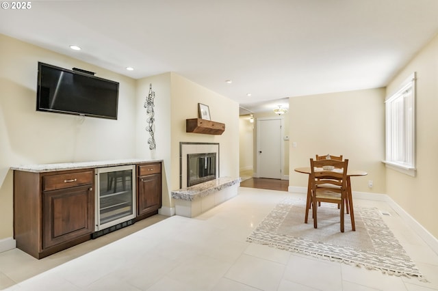 living area featuring recessed lighting, baseboards, wine cooler, and a fireplace