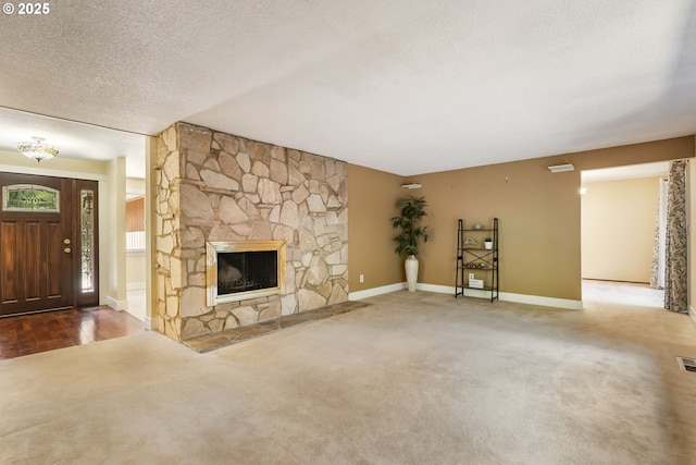 unfurnished living room featuring a fireplace, carpet floors, a textured ceiling, baseboards, and visible vents