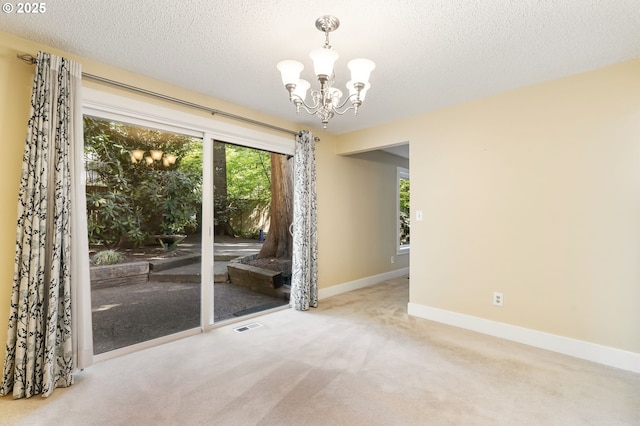 interior space featuring carpet flooring, a textured ceiling, a chandelier, baseboards, and visible vents