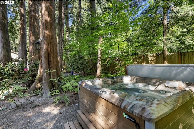 wooden deck featuring a hot tub and fence